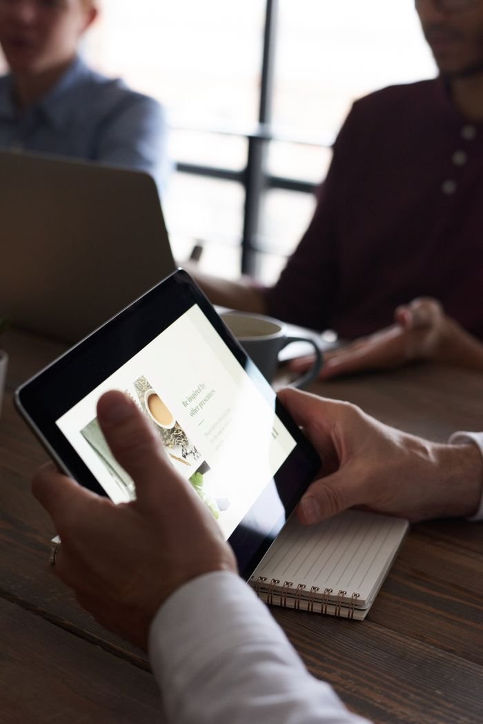 Professionals in a meeting, using a tablet for digital presentation and notes.